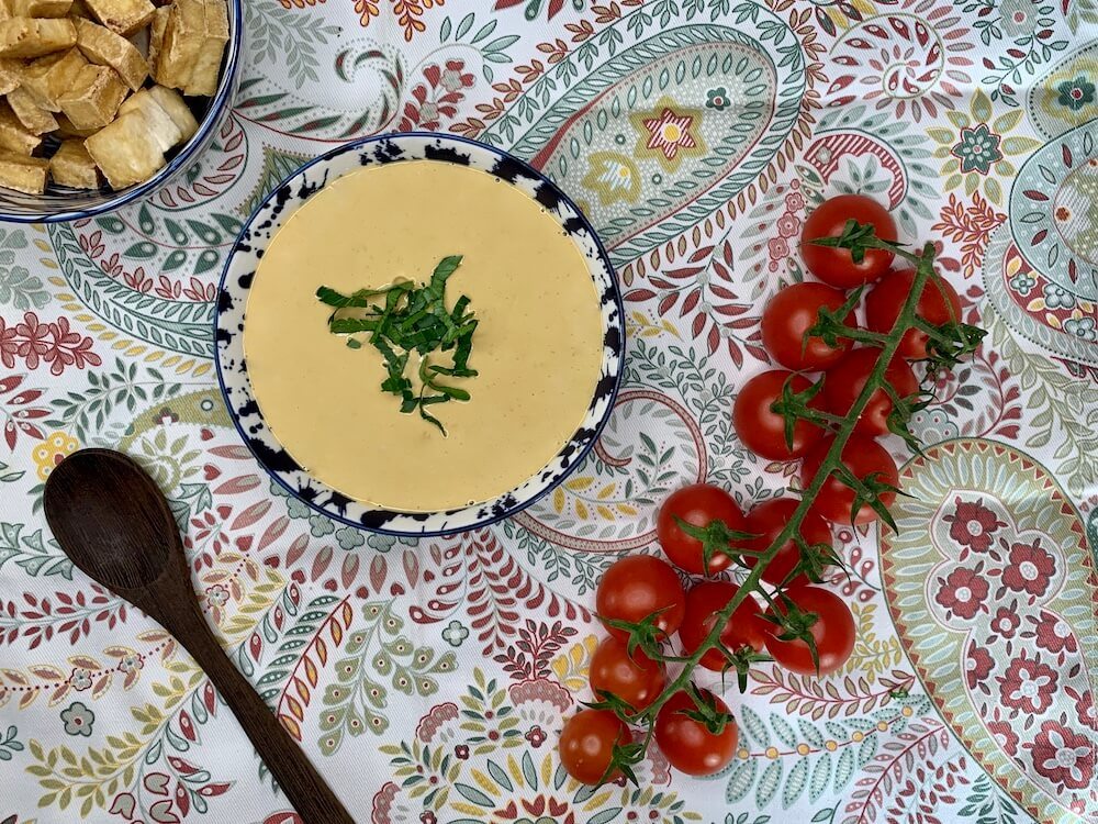 Bowl of spicy peanut sauce with cherry tomatoes on the side