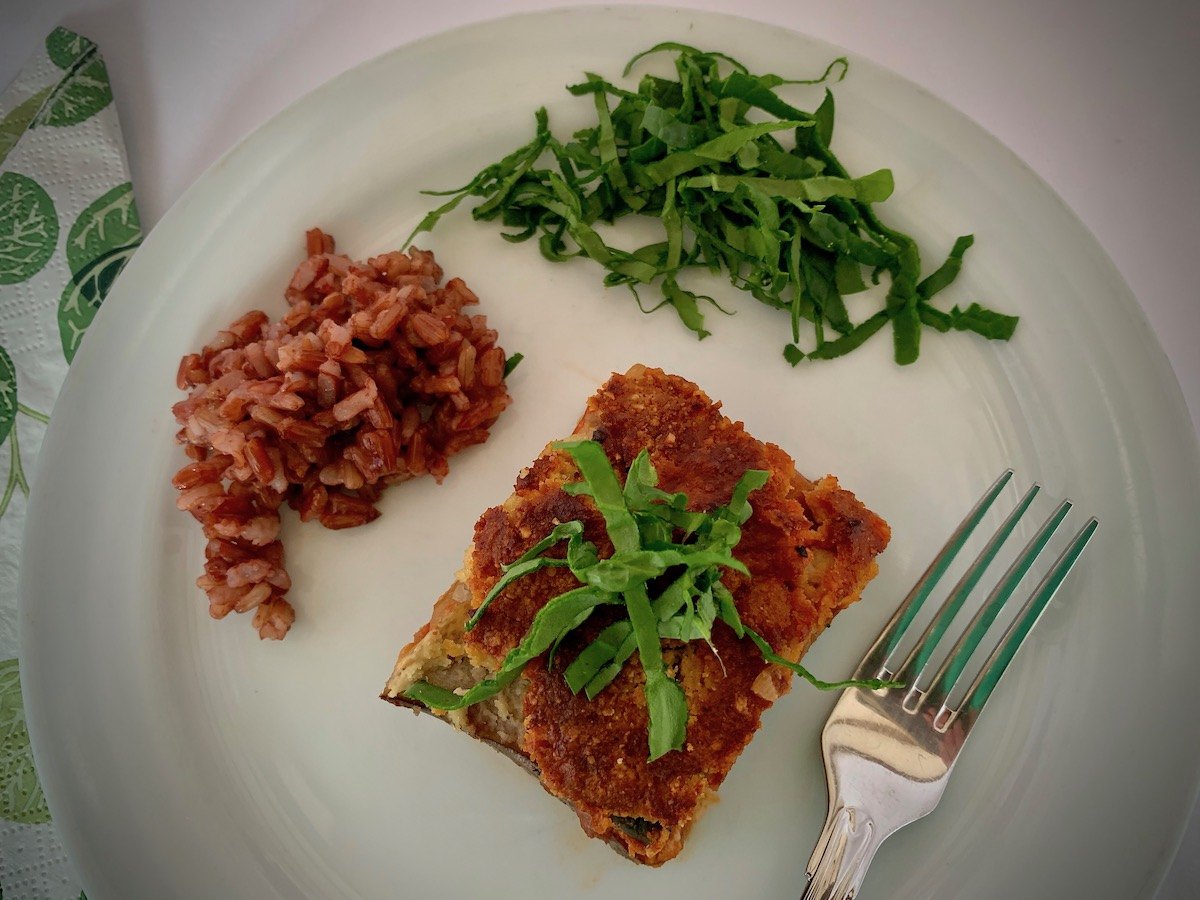 Slice of vegan eggplant parmesan and red rice