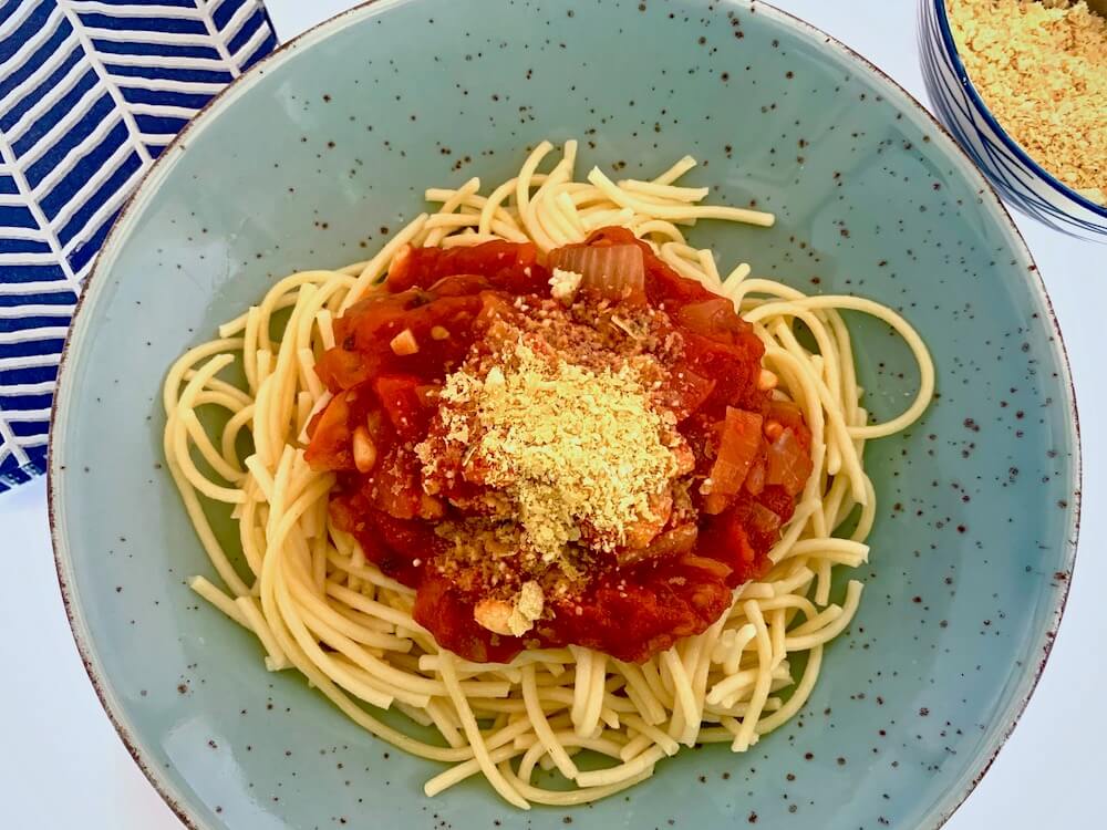 Bowl of spaghetti with tomato sauce and nutritional yeast
