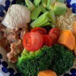 Vegan buddha bowl with quinoa, refried beans, broccoli and sweet potato