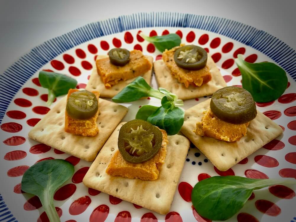 Vegan cheese with jalapeños on gluten free crackers