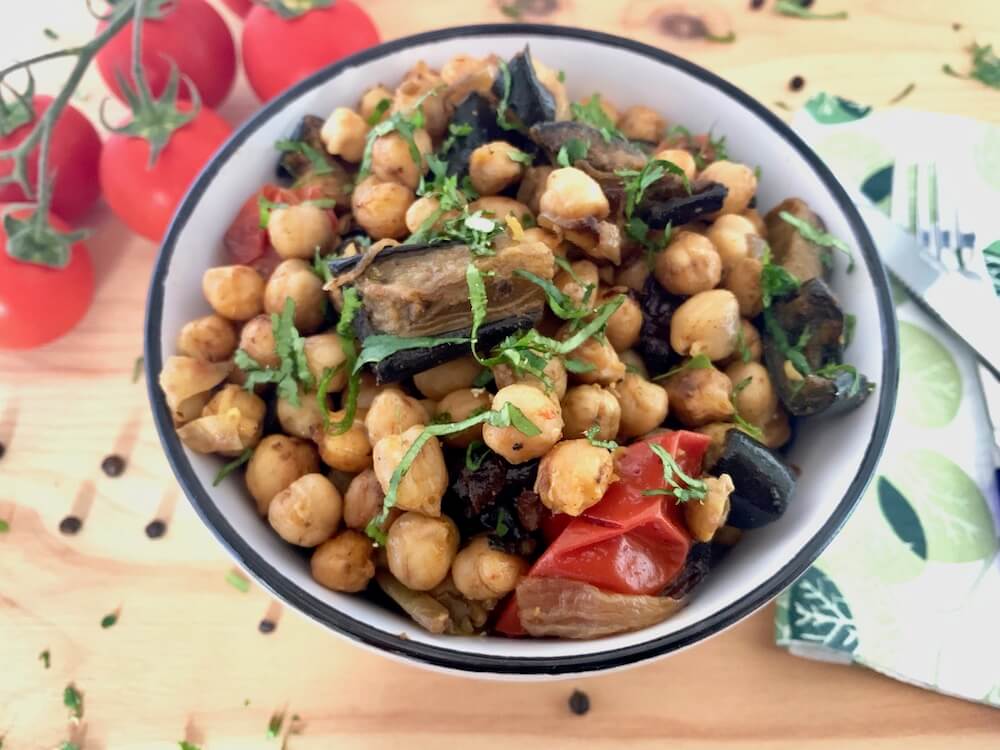 Bowl of roasted chickpeas with eggplant and cherry tomatoes