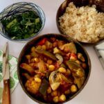 Bowl of eggplant curry with rice and spinach