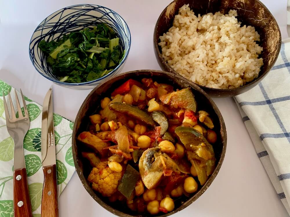 Bowl of eggplant curry with rice and spinach