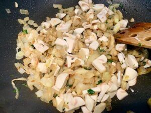 Onions, eggplant and mushrooms in a frying pan