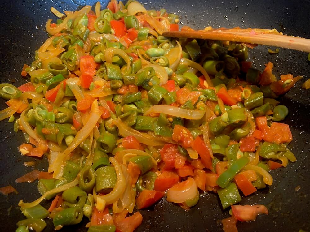 Frying broad bens with onions and peppers