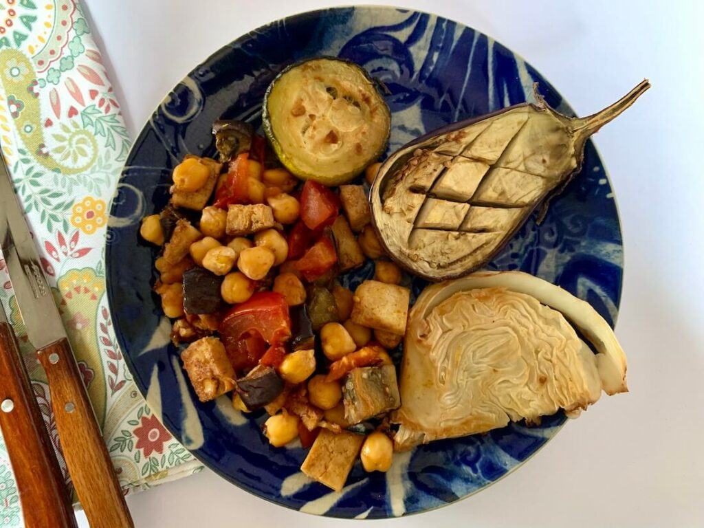 Plate with roasted eggplant, cabbage, zucchini and chickpea mix