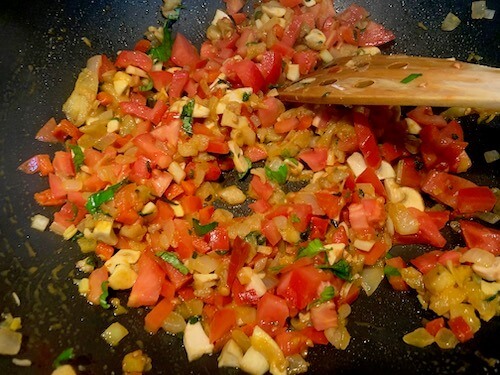 Onions, eggplant, mushrooms, red pepper and tomatoes in a frying pan