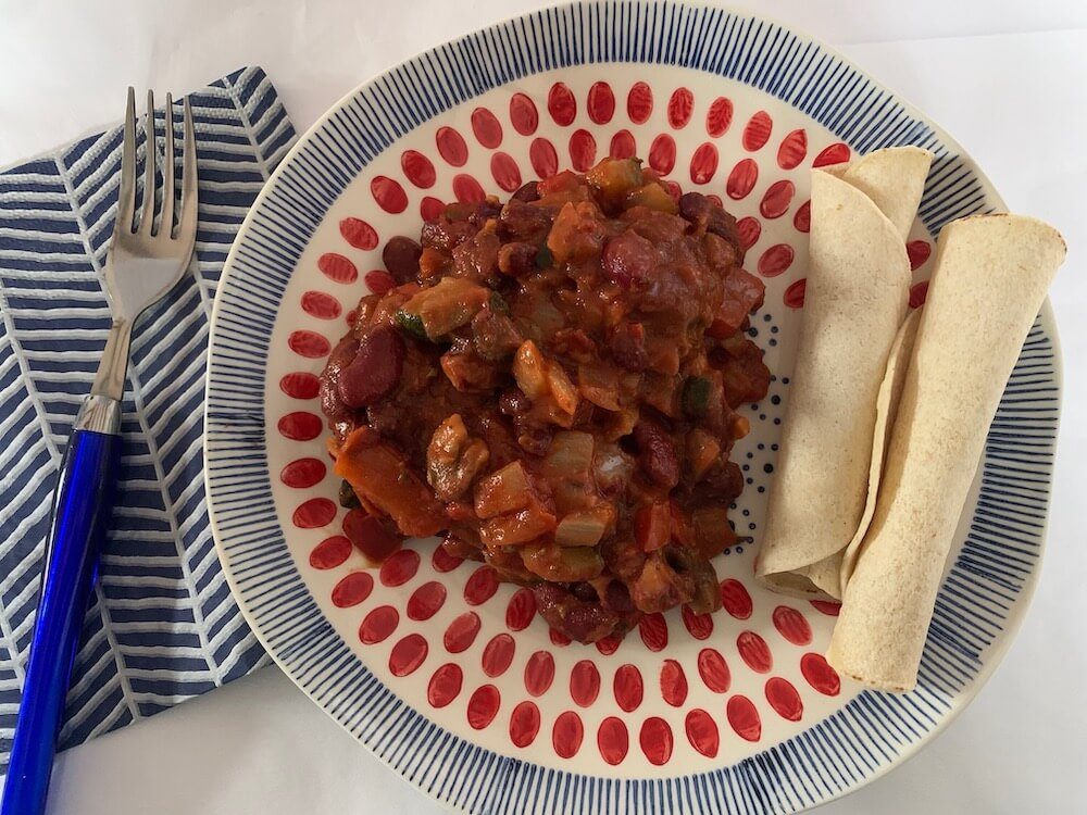 Plate of vegan chilli beans with gluten free wraps