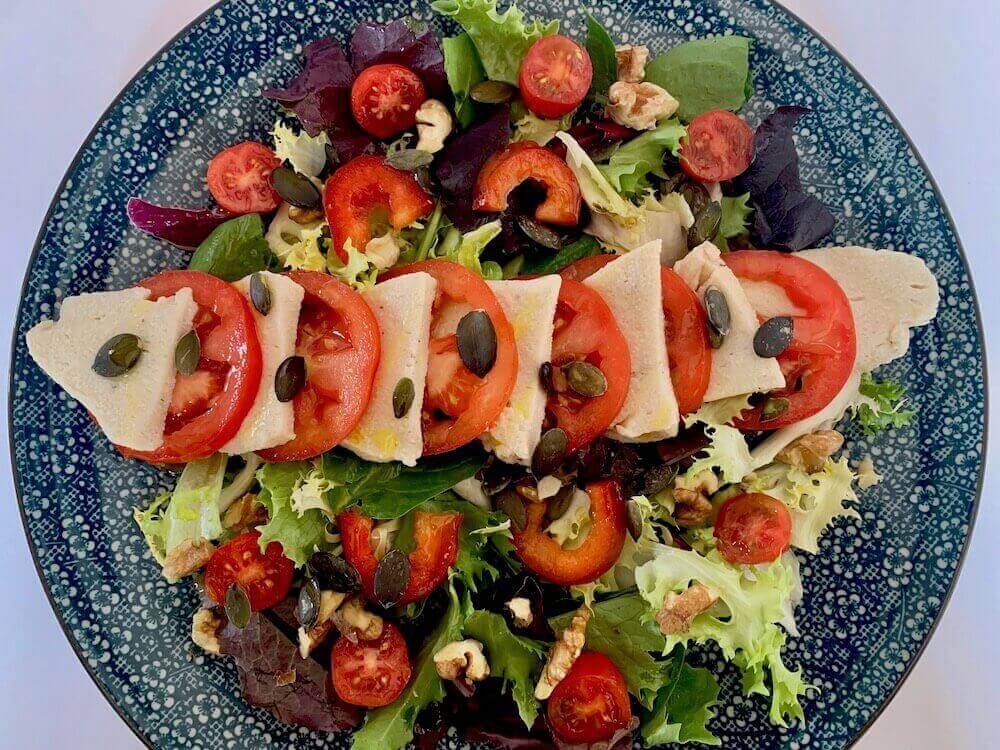 Plate of tomato and vegan mozzarella salad