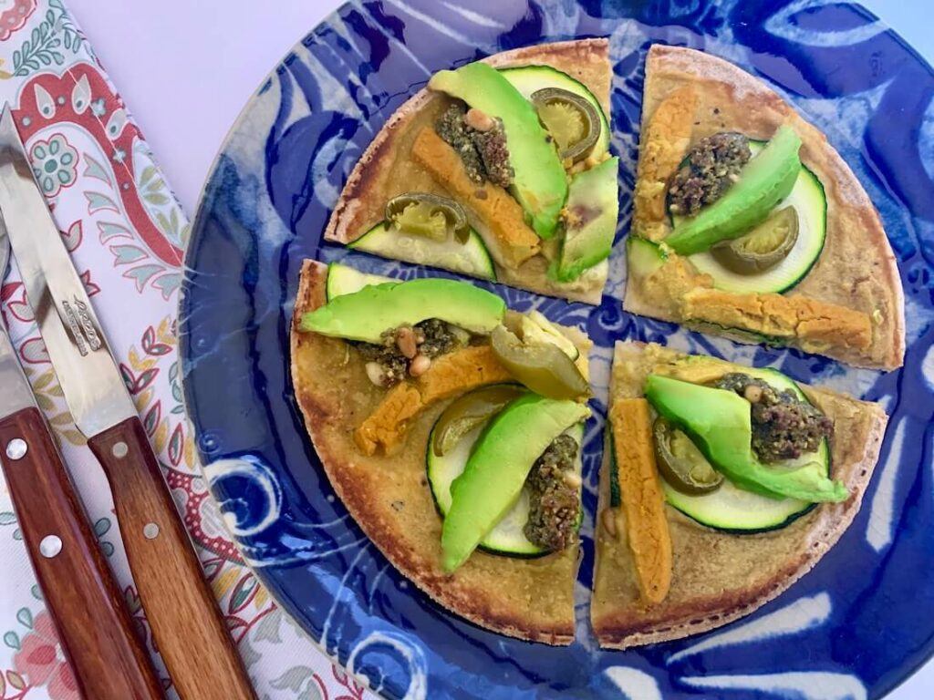 gluten-free vegan pizza hack with avocado, jalapeños and vegan cheese on top