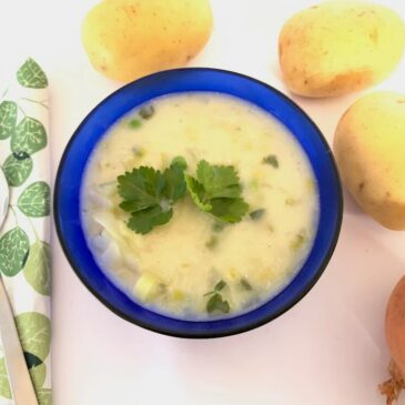 Blue bowl with quick potato soup and potatoes in the background