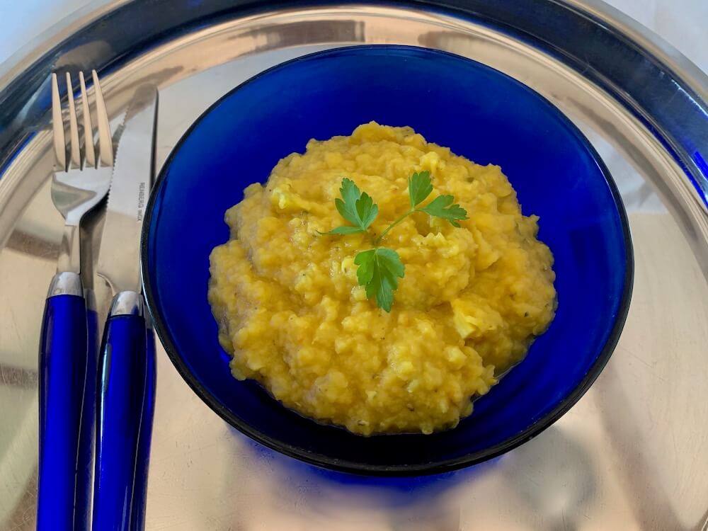 Yellow lentil dahl in a blue bowl