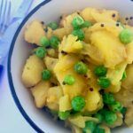 Potatoes and peas cooked in turmeric and black mustard seeds