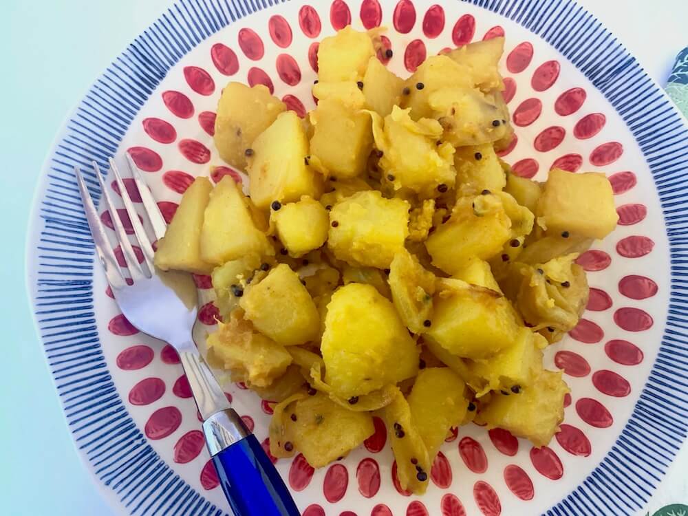Potatoes cooked in turmeric and black mustard seeds