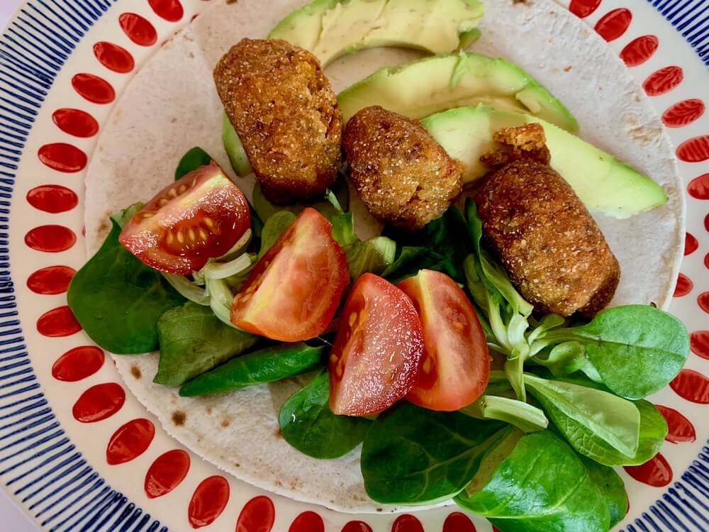 3 vegan balls from this vegan balls recipe served in a wrap with cherry tomato, lambs leaves and avocado.