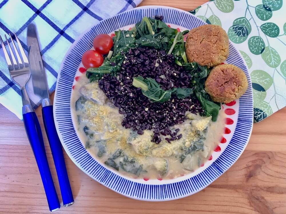 Easy vegan cheese sauce recipe, served with black rice, spinach and vegan croquette balls