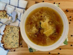 Bowl of vegan french onion soup with gluten free bread and nutritional yeast