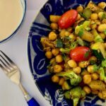 Bowl of quick chickpea recipe with broccoli & zucchini served with tahini sauce