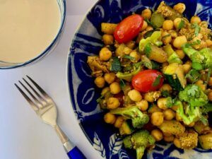 Bowl of quick chickpea recipe with broccoli & zucchini served with tahini sauce