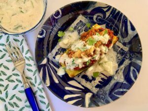 Vegan stuffed zucchini boat with raita sauce on top