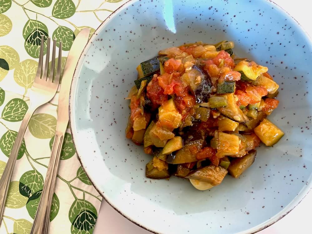 Spanish pisto recipe illustrated in a blue bowl