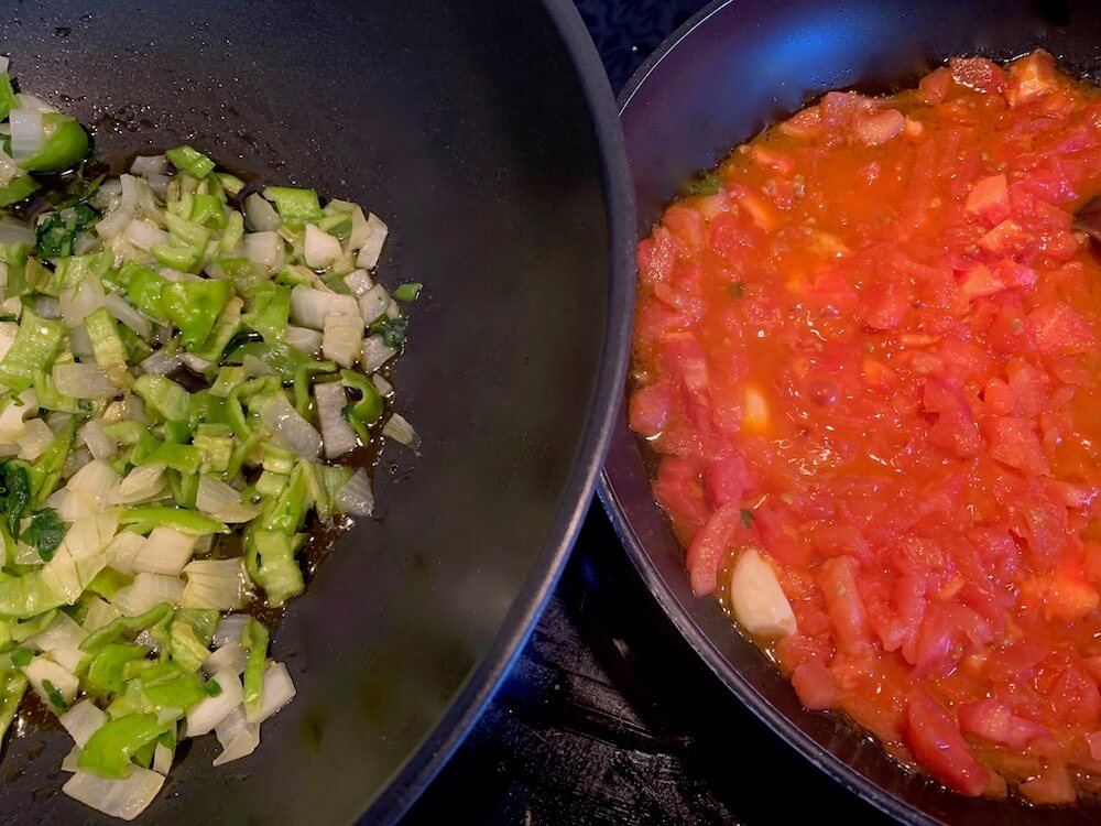 One pan with frying chopped pepper and one pan with frying tomato sauce