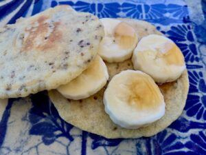 Vegan gluten free pancake with banana and maple syrup on top