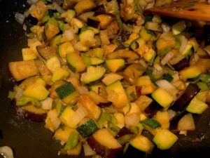 Vegetables for pisto frying in a pan