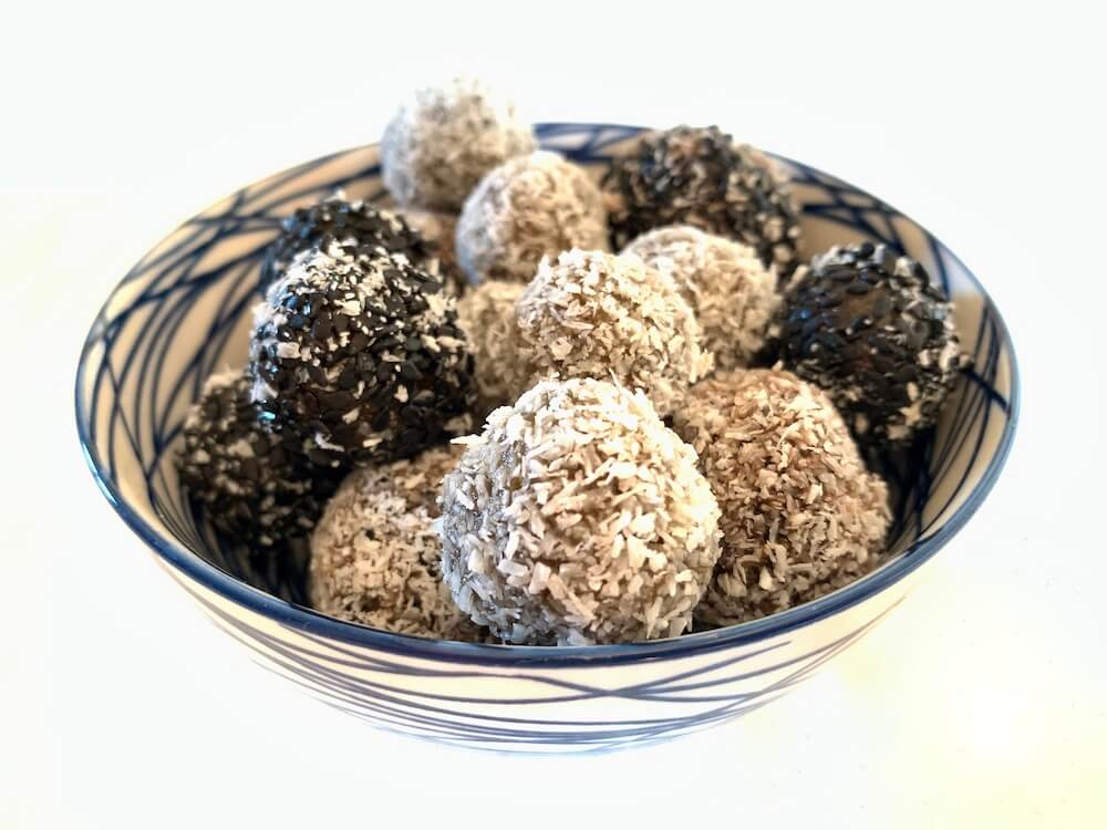No bake protein energy balls recipe - balls rolled in coconut and black sesame seeds