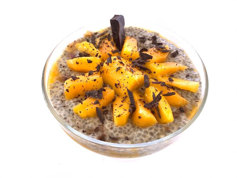 chia seed pudding with slices of mango and crumbled dark chocolate on top