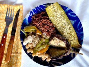 Blue plate with roasted vegetables, red rice & chickpea bake
