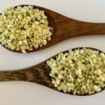 Two wooden spoons full of hemp seed