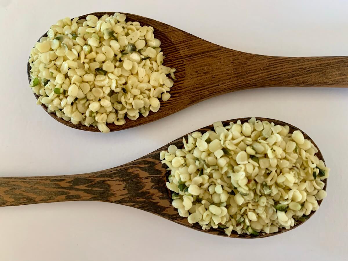 Two wooden spoons full of hemp seed