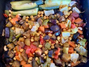 Pan of oil free vegetables and zucchini wedges roasted in aquafaba and orange juice