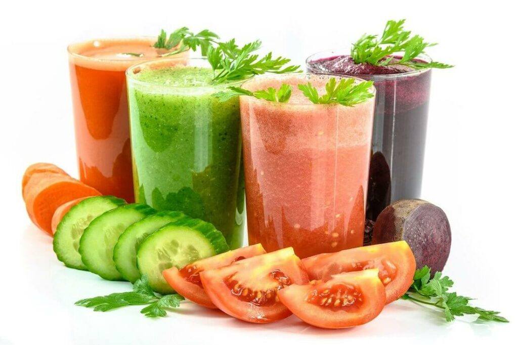 Four different coloured vegetable juices, two red, one purple and one green