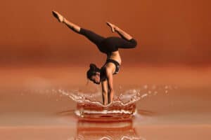 How to progress in yoga if you practise at home - woman standing on her hands in the water