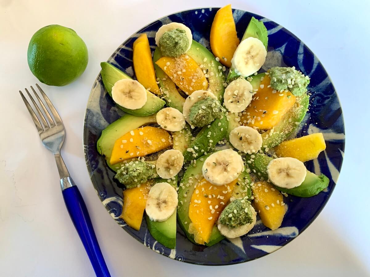 Plate of avocado & fruit topped with hemp seed