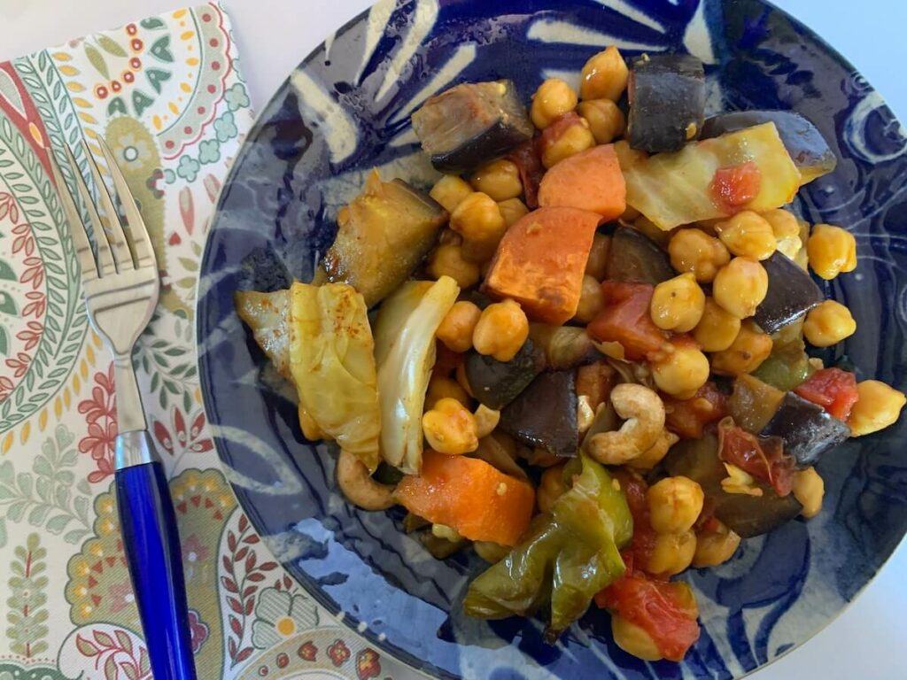 Plate of leftover chickpeas, sweet potato, cabbage and other veggies for breakfast