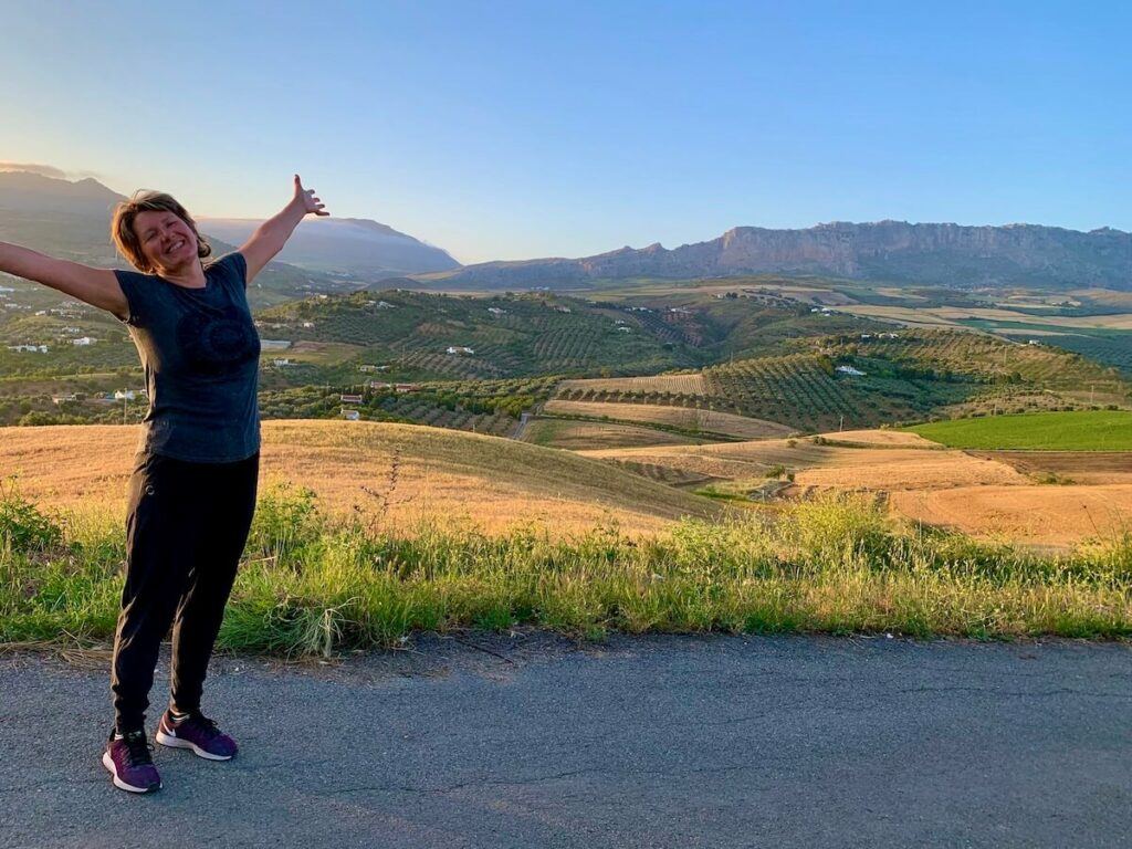 Joy of sobriety - person standing with arms in air with beautiful view in the background. 