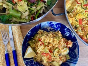 Bowl of vegetable paella with lemon and salad