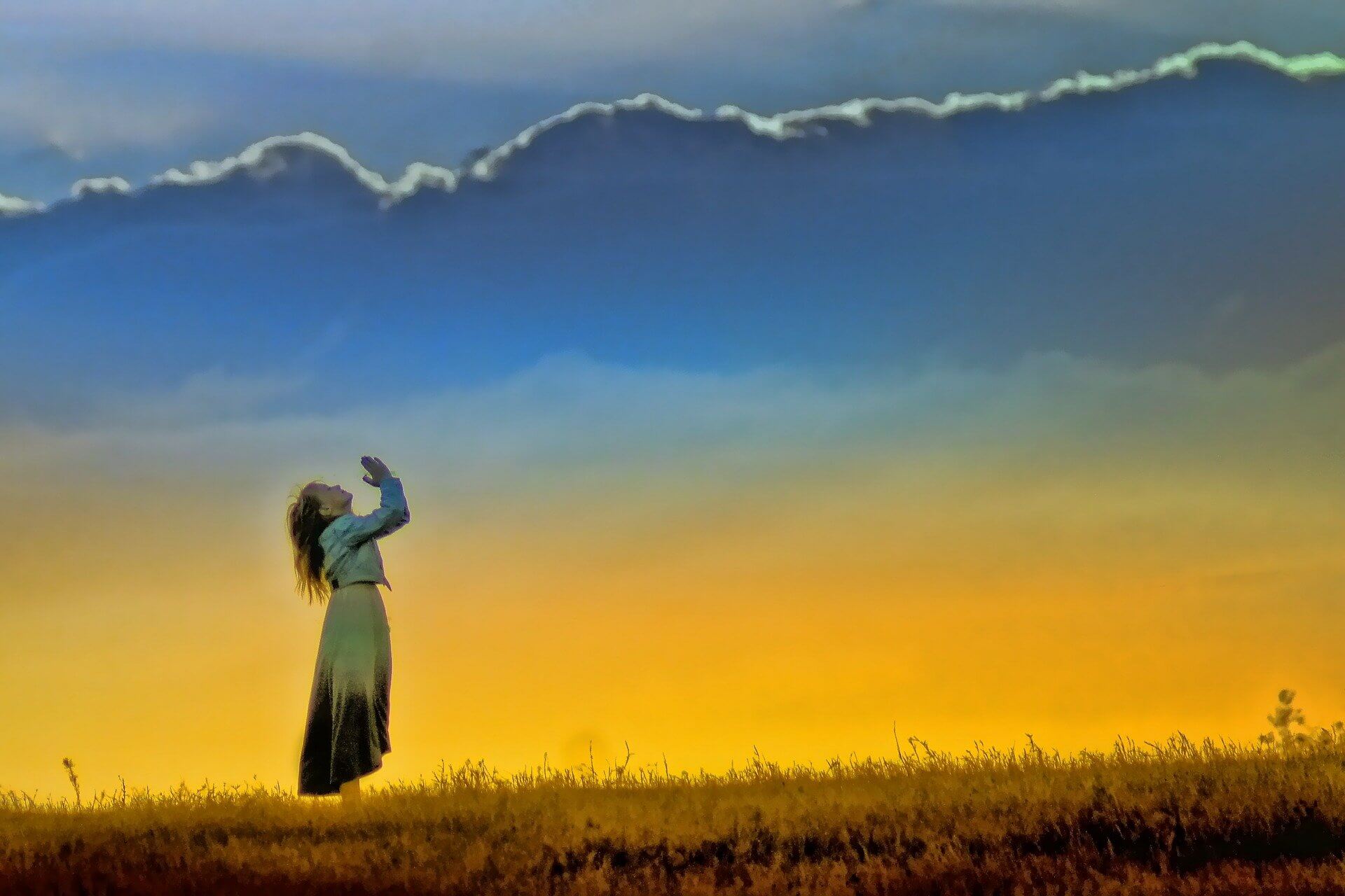Girl looking up at sky with hands clasped together