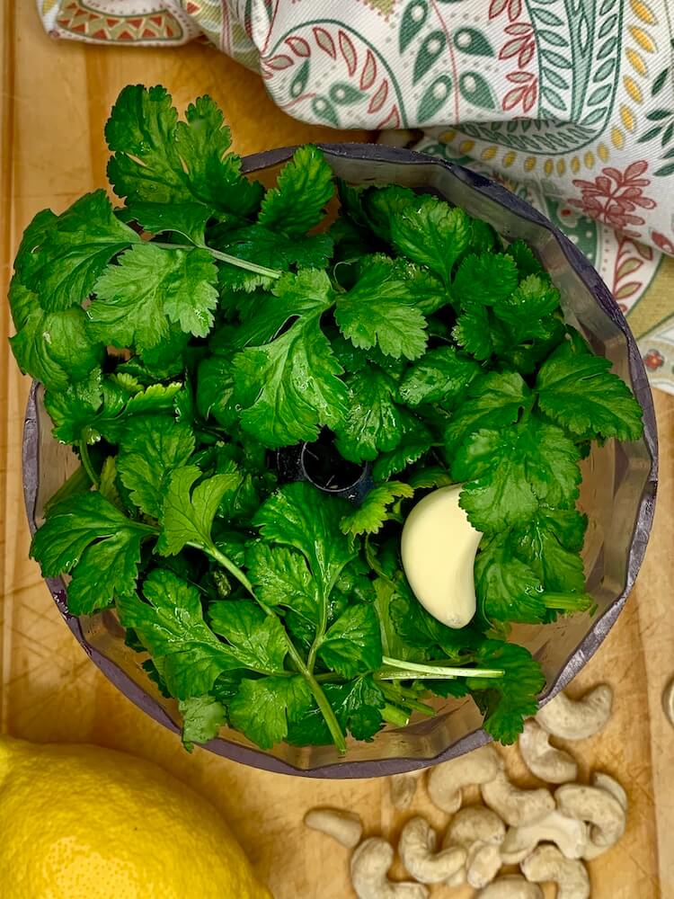 Fresh cilantro and a clove of garlic in the food processor