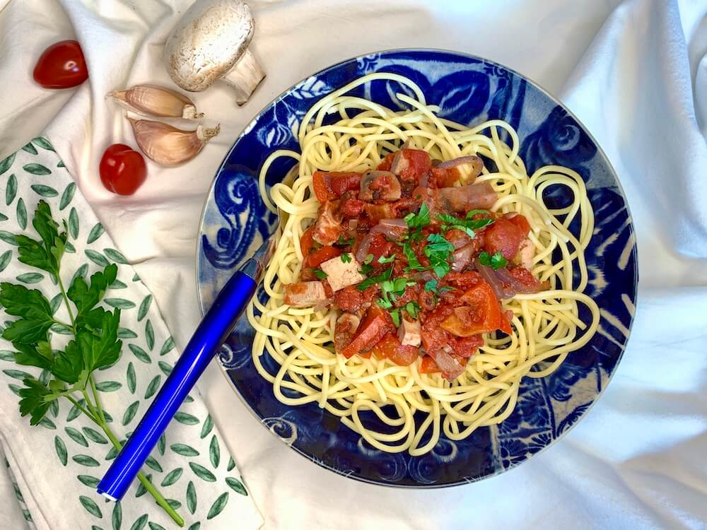 Spaghetti with oil free tomato sauce in a blue bowl