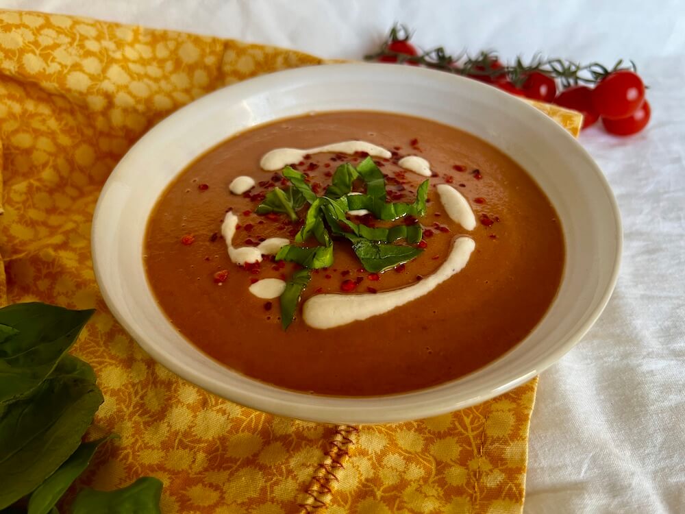 Roasted tomato soup with vegan cream and fresh basil on top