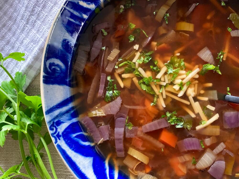 Bowl of easy vegan French onion soup with vegetables