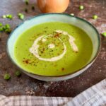 Bowl of easy vegan pea soup with chilli and cream on top