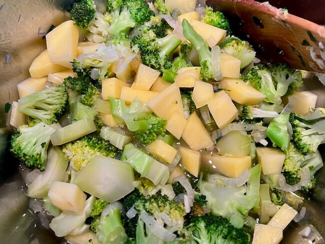 Broccoli, onion, garlic and potato in a pan