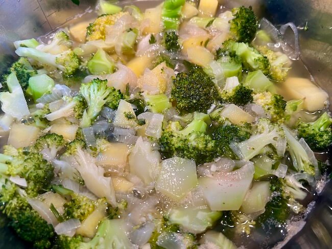 Broccoli, onion, garlic and potato covered by water 