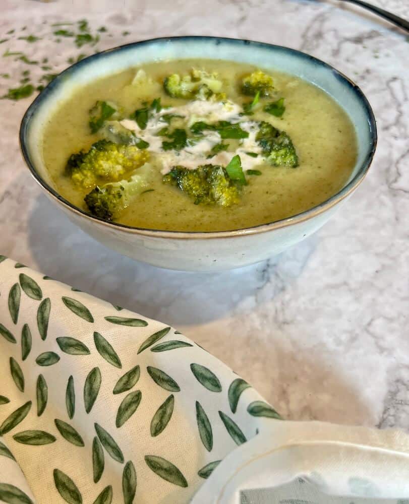 Bowl of broccoli cheese soup with cream and parsley